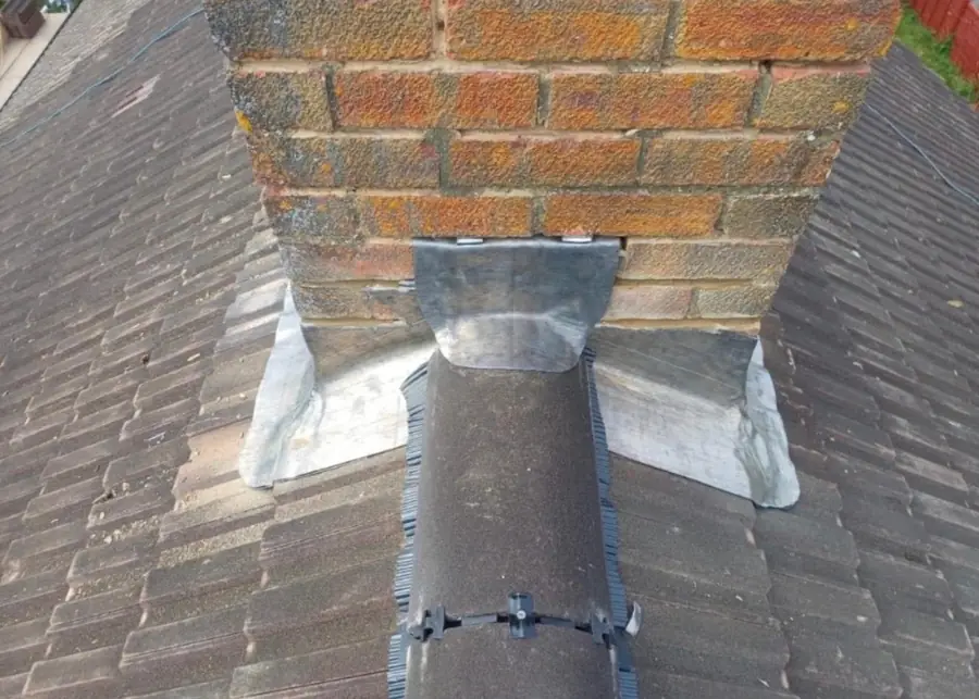 Lead back gutter and apron behind a brick chimney stack
