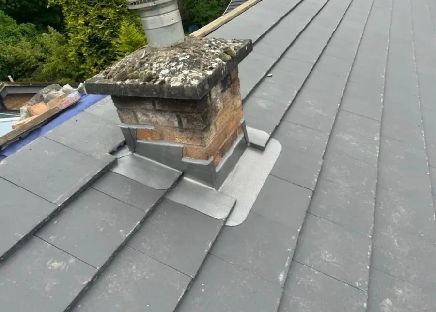 Brick chimney with new lead flashing on a slate-effect tile roof