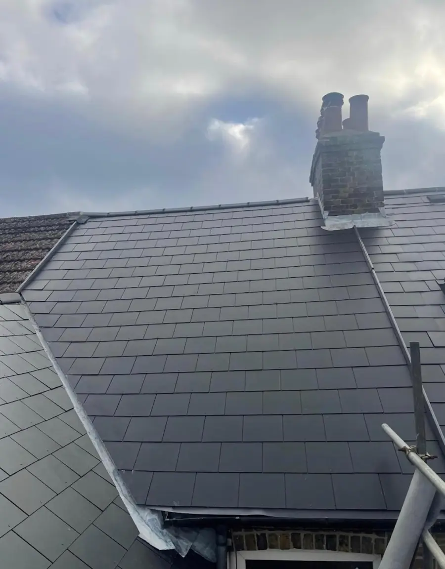Dark slate-effect roof finished up to a chimney stack