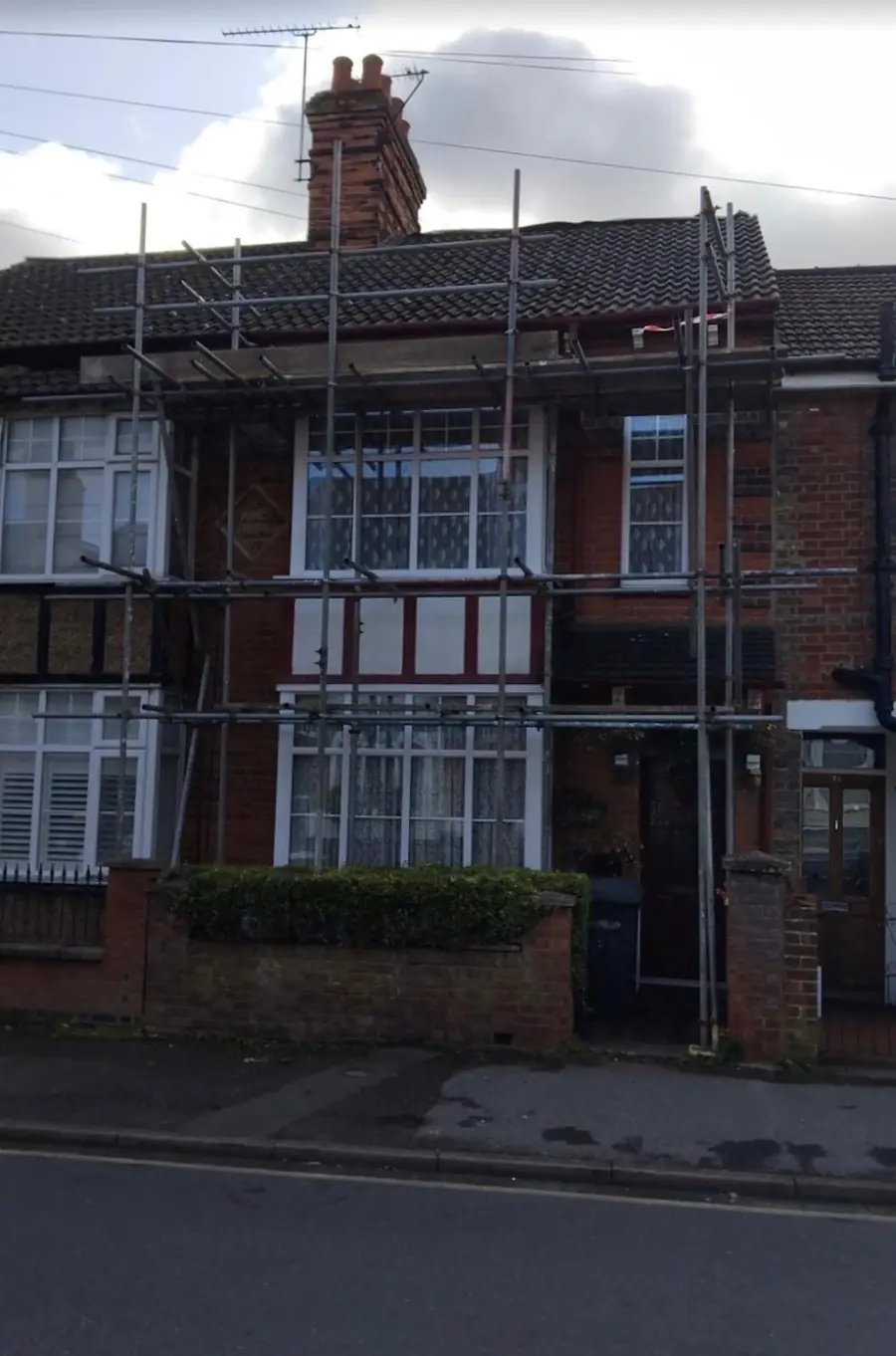 Edwardian terraced house with bay windows scaffolded for roof work