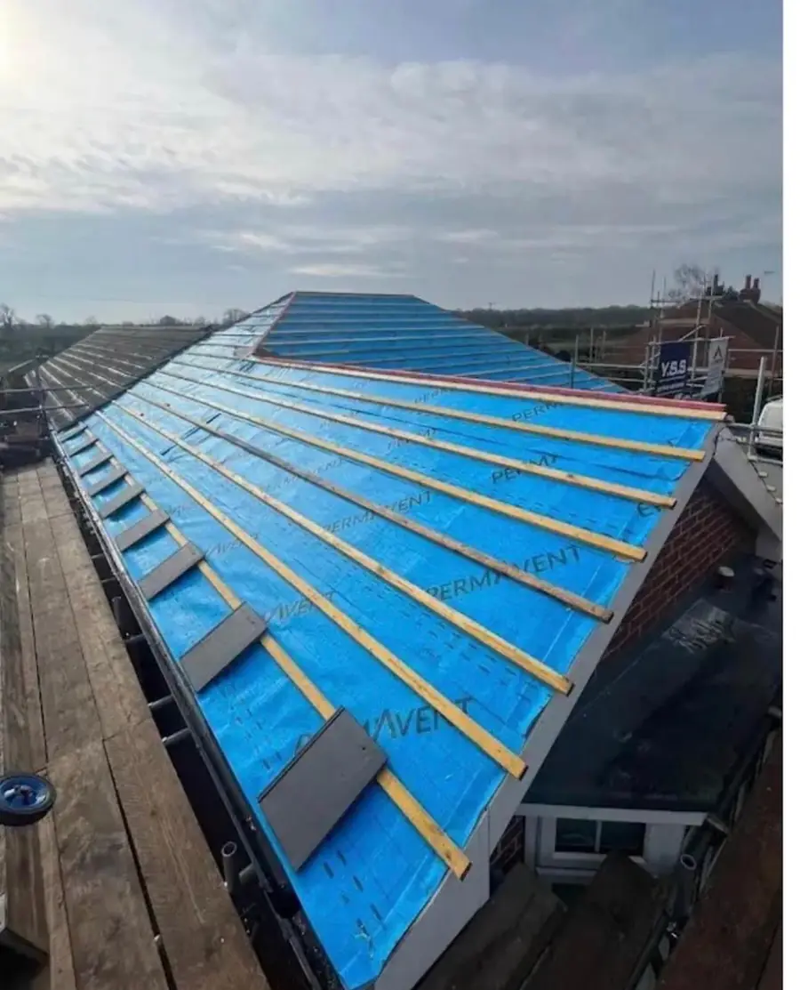 Re-roof in progress: new blue breathable membrane and treated battens on a long gable roof