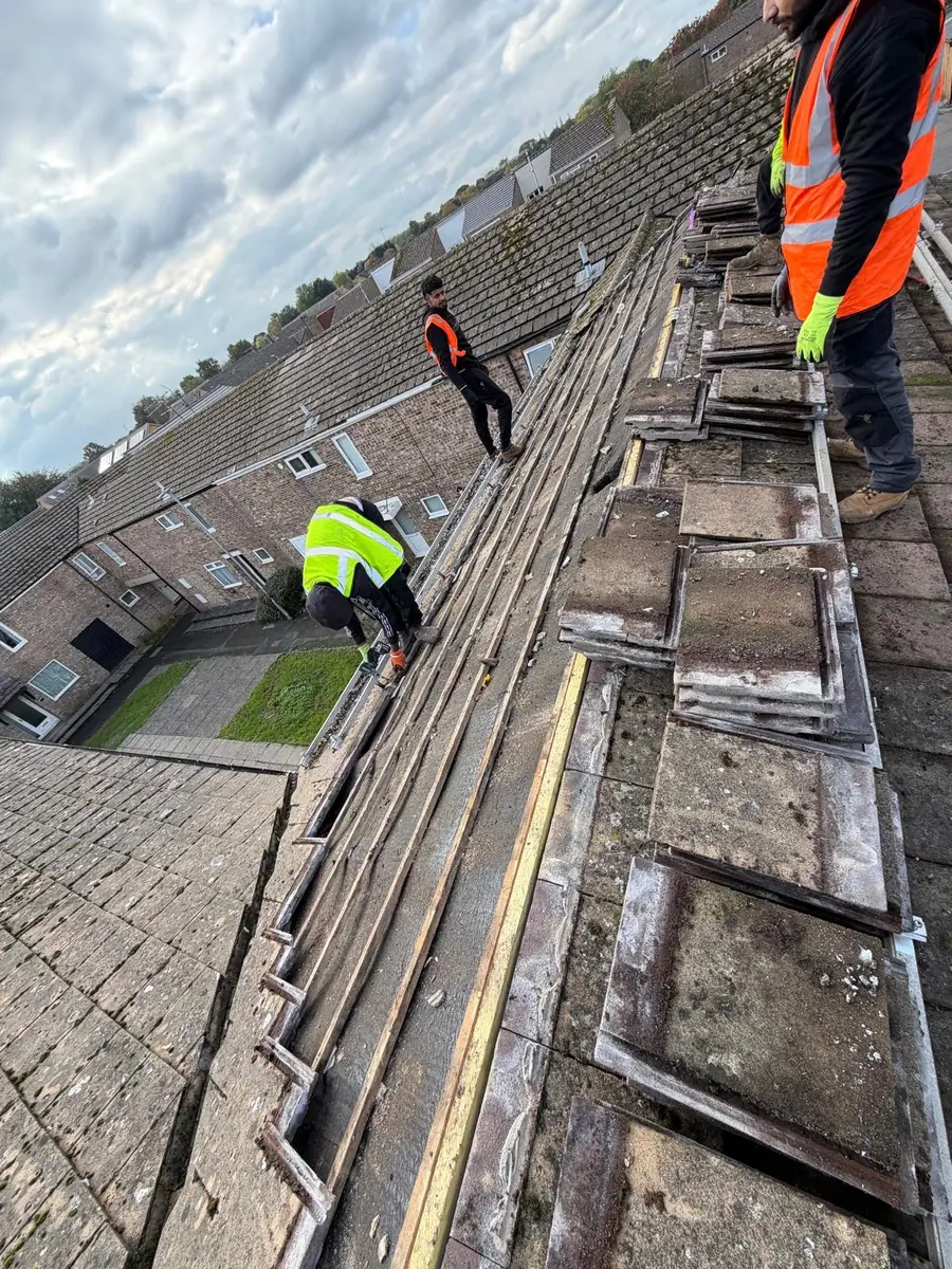 Best Top roofers stripping old concrete tiles off a terraced roof, tiles stacked on the slope