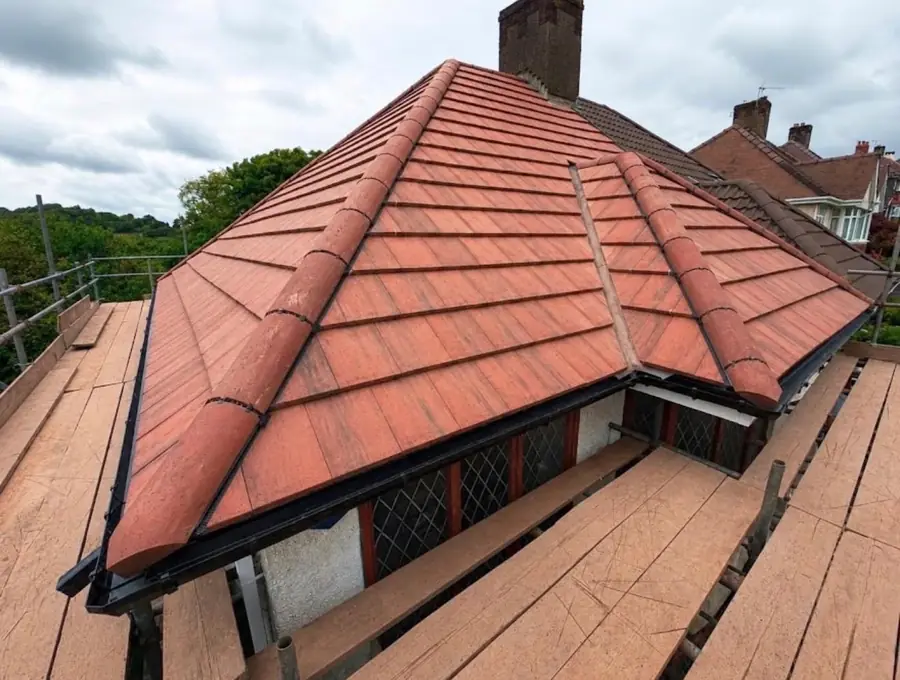 Red tile hip roof finished with dry hip and ridge on a detached house