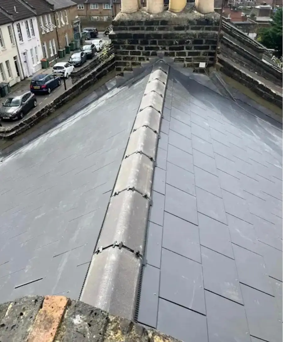 Slate-effect roof with a dry ridge between chimneys on a terraced street